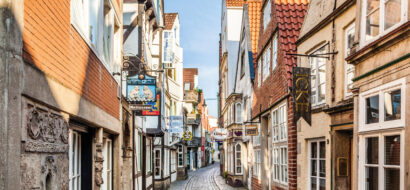 Eine malerische Altstadtgasse mit Kopfsteinpflaster und historischen Häusern lädt zum Flanieren ein.
